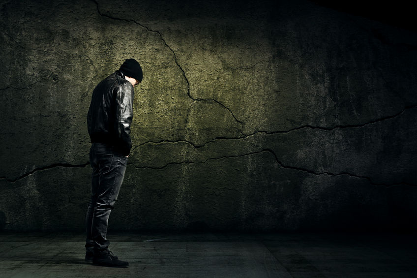 Man Alone against a wall, a grim dark tone