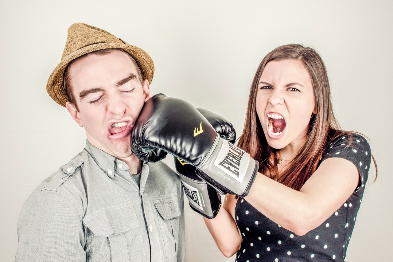 Woman punching man with boxer gloves